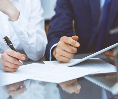 Closeup Of Two Bookkeepers Reviewing Financial Documents In-House Vs Outsourced Bookkeeping